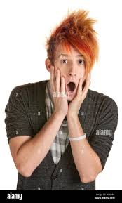 Primo piano ritratto di bell'uomo con capelli ricci contro l'arancio parete immagini . Uomo Spaventato In Arancione Capelli Pungenti Con Mani In Alto Foto Stock Alamy