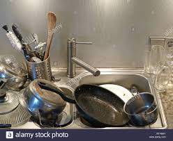 heap of dirty utensils in the sink