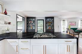 Black Quartz Waterfall Countertop In A Black And White Kitchen Kitchen Desig White Cabinets Black Countertops Gold Kitchen Hardware Black Granite Countertops