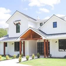 Black And White House Exterior One Story White Modern Farmhouse With Black Windows And Wood Accents House Exterior Modern Farmhouse Exterior House Designs Exterior