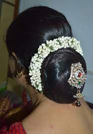 This Beautiful Traditional Low Bun Decorated By A Gajara Of Artificial Flower Buds Low Bun Hairstyles Bun Hairstyles For Long Hair Indian Wedding Hairstyles