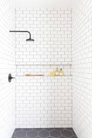 An Oil Rubbed Bronze Shower Head Is Fixed To White Subway Shower Surround Tiles Accented With B White Tile Shower White Bathroom Tiles White Subway Tile Shower