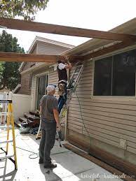 The pergola ceiling is made of plumbing pipe, while the house, partition, and garage are faced in cement. Build A Patio Pergola Attached To The House Houseful Of Handmade