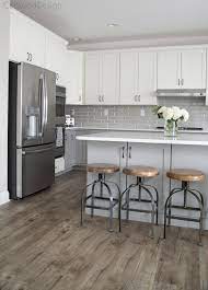 Glossy Grey Subway Tiles In Large White And Grey Kitchen White Kitchen Design Gray And White Kitchen Grey Wood Floors Kitchen