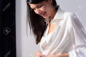 Young Woman Unbuttoning Her White Shirt As She Prepares To Go ...