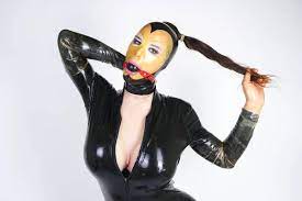 Travesti courbé chaud portant un masque en caoutchouc de latex et costume  fétiche noir. pervers personne avec bdsm gag dans les mains sexuellement  jouer . — Jouet, Contexte - Stock Photo | #275688450