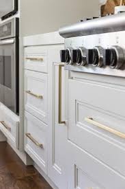 Long Thin Brass Pulls On White Kitchen Cabinets Brings A Warm Glowing Appeal To The Fresh White White Marble Countertops Light Grey Kitchens Island Countertops