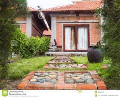 44 casas con diferentes materiales, adobe, caña, container, ladrillo de cemento, ladrillo rojo, palets, piedra, bambú y madera. Casa De Un Piso En Estilo Oriental Con Las Ventanas Panoramicas Del Ladrillo Rojo Tina De La Arcilla Con Agua Trayectoria De Pi Foto De Archivo Imagen De East Ciudad 120935176