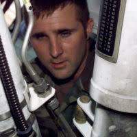 Hospital Corpsman 2nd Class Daniel Rahe treats a head laceration