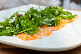 Preparate un'emulsione con 4 cucchiai di aceto di mele , succo di limone, salsa di soia e un cucchiaio di disponete il salmone in una pirofila e adagiate le fette di pesce nel composto. Carpaccio Di Salmone E Rucola Ginger Tomato