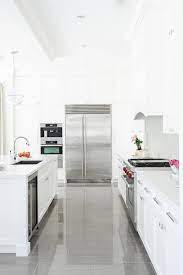 If dark feels a bit too overwhelming for your kitchen or style, go a few shades lighter with medium colors. White Kitchen With Gray Floor Tiles Transitional Kitchen Enviable Designs