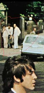 Who are the people next to the blue car in the background