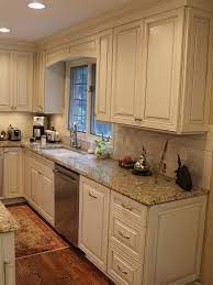 With refinements such as countertop flatware drawers and multiple tableware displays, this tailored kitchen featuring off white cabinets with glaze has a clear spirit of hospitality. Cream Cabinets With Cocoa Glaze Nvg Granite White Subway Tile Trendy Kitchen Backsplash Cream Kitchen Cabinets Kitchen Renovation