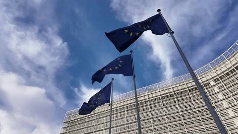 European Union flag flying in front of the European Commission building in Brussels, Belgium.