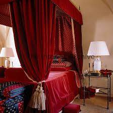 The most common canopy bed drapes material is cotton. Sumptous Red Velvet Drapes With A Red And Gold Lining Hang Around This Four Poster Bed Red Velvet Curtains Velvet Drapes Rustic Curtains