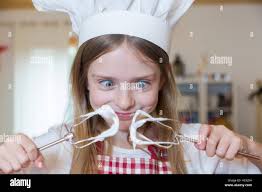 Portrait of staring girl with stirrer and chef's hat Stock Photo