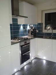 White kitchen with grey worktops. White Gloss Kitchen With Grey Tiles Novocom Top