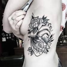 Floral tattoos have become common elements in the tattooing work as most of the tattoos are incorporated with flowers. Black Shaded Flowers And Realistic Heart Tattoo On Left Upper Body For Women