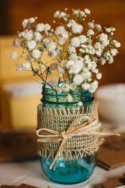 Blue Mason Jars Filled With Baby S Breath And Wrapped With Burlap Add A Rustic Touch To Weddings And Mason Jar Wedding Wedding Jars Rustic Wedding Centerpieces