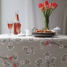 Nappe en toile cirée ovale, fonds blanc avec de jolis motifs gris clair. Nappes De Jardin En Coton Enduit Fleur De Soleil