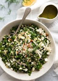 Overhead Photo Of Kale And Quinoa Salad In A White Rustic Salad Bowl With A Small Jug Of Lemon Dressing On Kale Quinoa Salad Quinoa Salad Recipes Rustic Salad