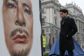 Artist hangs giant portrait of Gadaffi opposite houses of parliament