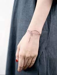 Dive into art, photos and fashion images with design press. Wrist Ribbon Tattoo Tiny Wrist Tattoos Wrist Tattoos For Women Elegant Tattoos