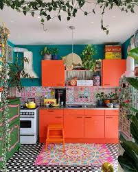 The black cabinet with a wood countertop works as the focal point which gives a bold touch, creating the monochrome overall look. A Kitchen With Dark Orange Cabinets That Complement The Teal Backing Of The Space Bohemian Kitchen Decor Home Kitchens Kitchen Interior