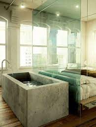 A Industrial Bedroom With A Concrete Bathtub Separated With A Glass Divider From The Bed Bedroom With Bath Concrete Bath Concrete Bathtub