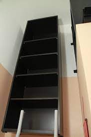 The rail screws into the wall studs and has many holes so there's always a hole over a stud. Suspended Besta Bookshelf Ikea Hackers