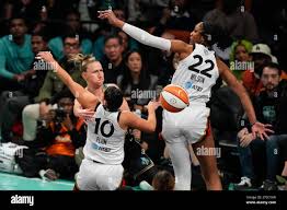 New York Liberty's Courtney Vandersloot, right, passes around Las Vegas  Aces' Kelsey Plum (10) and A'ja Wilson (22) during the first half in Game 4  of a WNBA basketball final playoff series