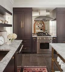 Beautiful Kitchen Features Dark Brown Stained Cabinets Adorned With Brass Cup Pulls Topped Wi Brown Kitchen Cabinets Dark Brown Kitchen Cabinets Brown Cabinets