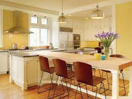 Angled kitchen island in the large kitchen area. Picture Of Yellow Combo Kitchen Design With White Island And Dini Kitchen Island Dining Table Kitchen Dining Room Combo Layout Kitchen Island Table Combination