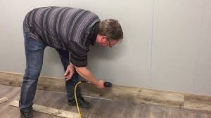 Mann Mit Nagelpistole Bolzenschussgerat Verlegt Laminatdiele An Der Wand Laminatboden Wandverkleidung Laminat