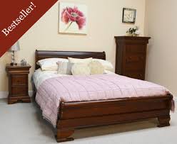 Vintage queen sized sleigh bed featuring paneled head and foot boards with serpentine shape and flared feet. Mahogany Sleigh Bed Low Footboard