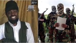 In the new video he was seen holding a qu'ran and book which he was reading from, sitting between two islamist fighters armed with machine gun. Shekau Mocks President Buhari Jonathan And Army Chief In New Video Naijaloaded