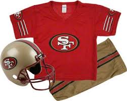 Blonde boy in american football uniform with black jersey and long hair. San Francisco 49ers Kids Youth Football Helmet Uniform Set Football Helmets San Francisco 49ers Youth Football