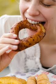 Person holding brown doughnut with white cream photo