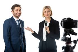 More customers, and more earnings. Smiling News Anchor Pointing At Happy Businessman During Interview Near Digital Camera Isolated On White Blurred Foreground Free Stock Photo And Image