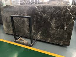 It is furnished with a curved sofa, various shaped coffee tables and a pair of white faux fur chairs over a round brown shaggy rug. China Good Price Armani Grey Brown Black Marble Slabs For Interior Living Room Floor Wall Decoration China Cut To Size Tiles Grey Marble