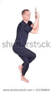 Practicing Yoga Exercises Man Doing Yoga Exercises In Studio On White Background Pose Name Eagle Pose Garudasa Yoga Photoshoot How To Do Yoga Yoga Fitness