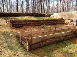 Raised Garden Beds On A Hill Looks Like They Bought Slab Wood Long Enough To Fit The Beds Sloped Garden Hillside Garden Terraced Garden Beds