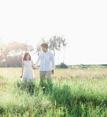 Even a resort village with. Positive Young Asian Couple Walking On Grassy Meadow Free Stock Photo
