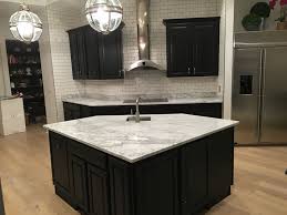 Green patterned bar stools sit at a dark wood kitchen island that complements with the upper cabinets. Bonney Lake Wa Black Cabinet Kitchen Countertop Granite Marble Quartz Granite Countertops Seattle