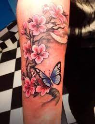 Beautiful Pink Ink Cherry Blossom And Blue Ink Butterfly Tattoo On Arm Butterfly Tattoos For Women Butterfly Tattoos On Arm Tattoos