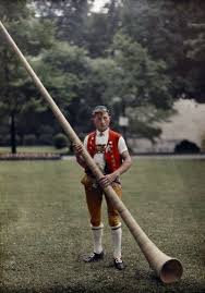 A Swiss Man Stands With An Alphorn Instrument By Hans Hildenbrand Cor Des Alpes Suisse Vacances Mer