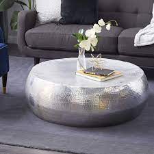 The table is available with silver metallic poufs that provide additional places to sit. Deco 79 23913 Round Hammered Aluminum Metallic Silver Coffee Table 42 X 14 Buy Online In Botswana At Botswana Desertcart Com Productid 16024923
