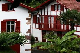 With Its White Washed Walls Exposed Red Coloured Beams Long Wooden Balconies And Front Door Decorated With A Lintel Bearing Maison Basque Maison Pays Basque