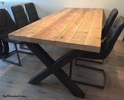 oude grove houten balken die het blad vormen voor een tafel met stalen kruis onderstel sloophout oudhout staal indus tafel hout staal tafel thuisdecoratie