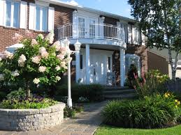 Amenagement D Une Facade De Maison Muret Celtik De Permacon Dalles De Pave Mondrian De Permacon Arbustes Graminees Et Vivaces House Styles Mansions House
